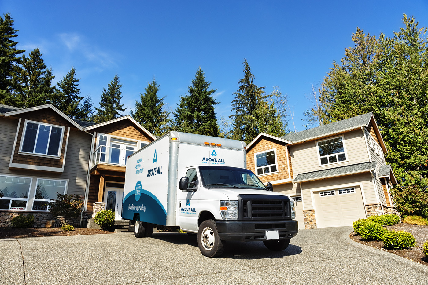White Above All Roofing, Siding and Insulation box truck parked in a residential driveway.