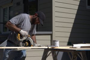 A worker uses a power saw to cut lumber