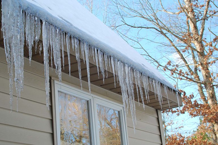 Section of roof and gutters showing extensive ice and icicles hanging