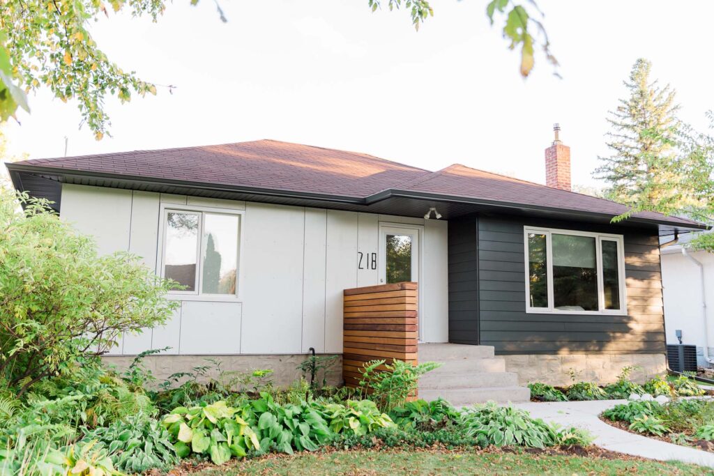 Updated home exterior with mixed siding, wood accents, and garden path