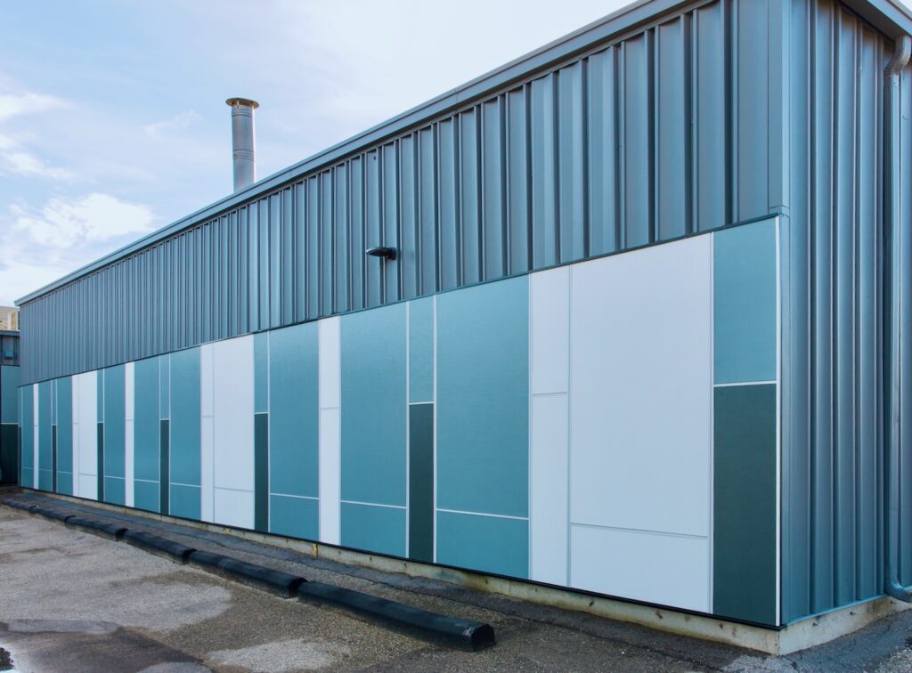 Commercial building exterior with blue and white metal wall panels and vertical metal siding.