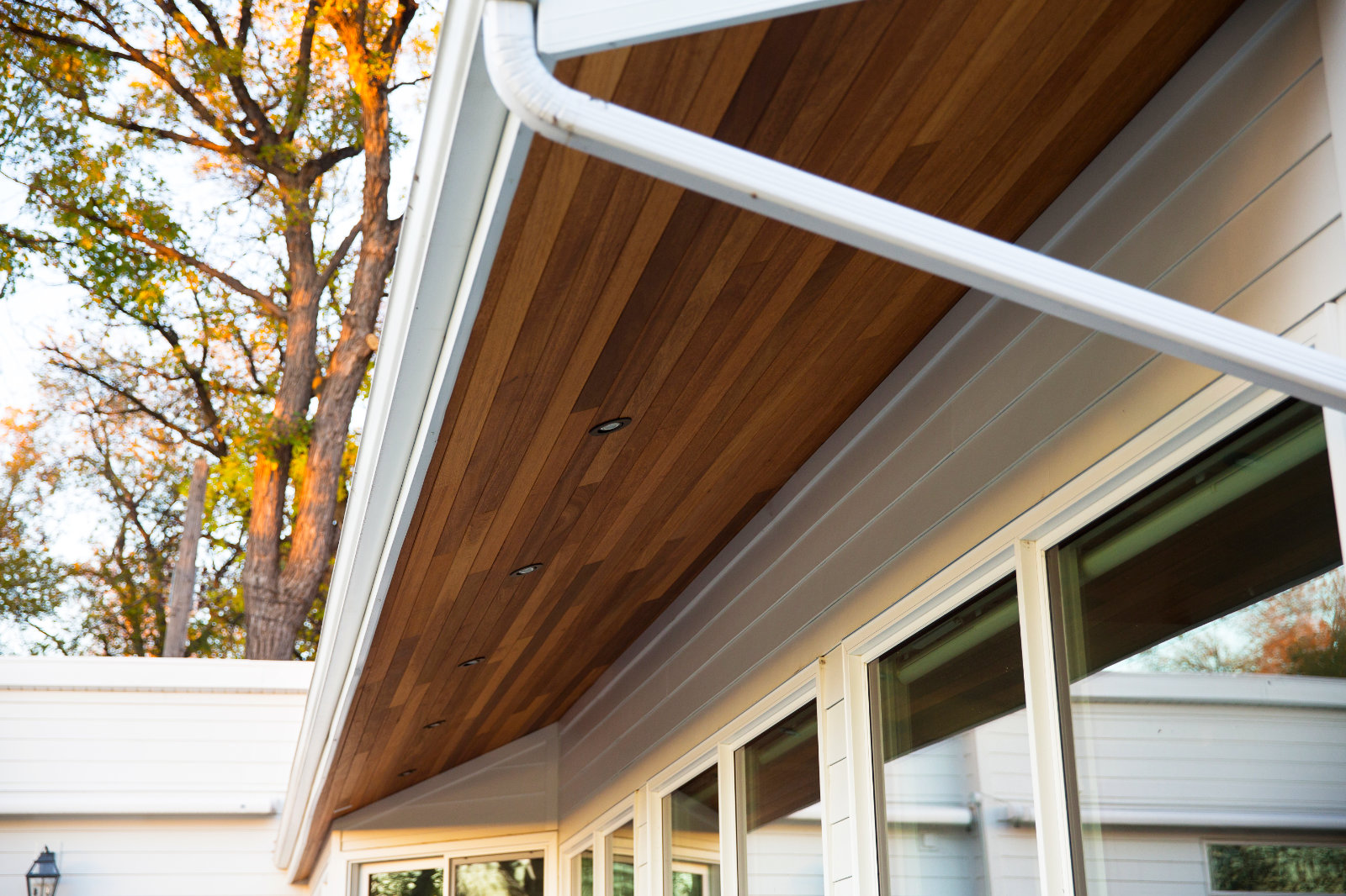 Wood-look soffit with white gutters and modern exterior windows