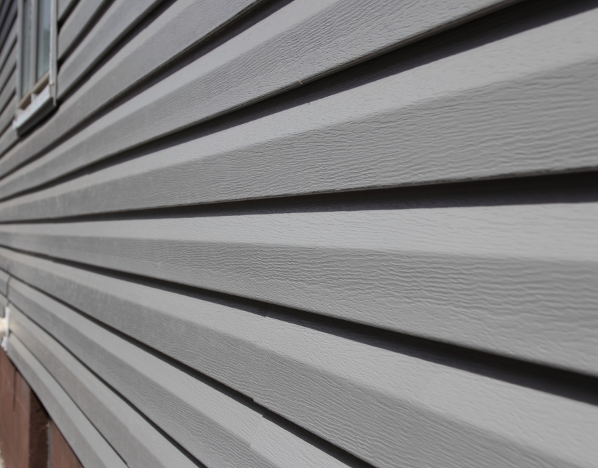 Close-up view of grey vinyl siding installed on a home exterior