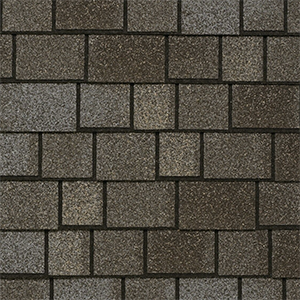 Close-up of grey brownish architectural shingles with contrasting layered tabs