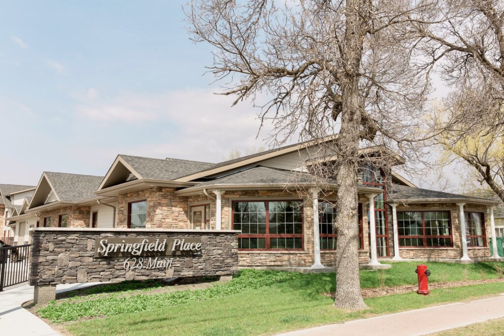 Front view of Independent senior home Springfield Place, with sign and windows of building.