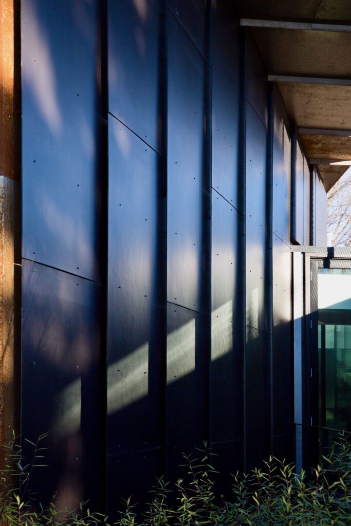 Dark metal cladding and vertical fins on a modern building exterior