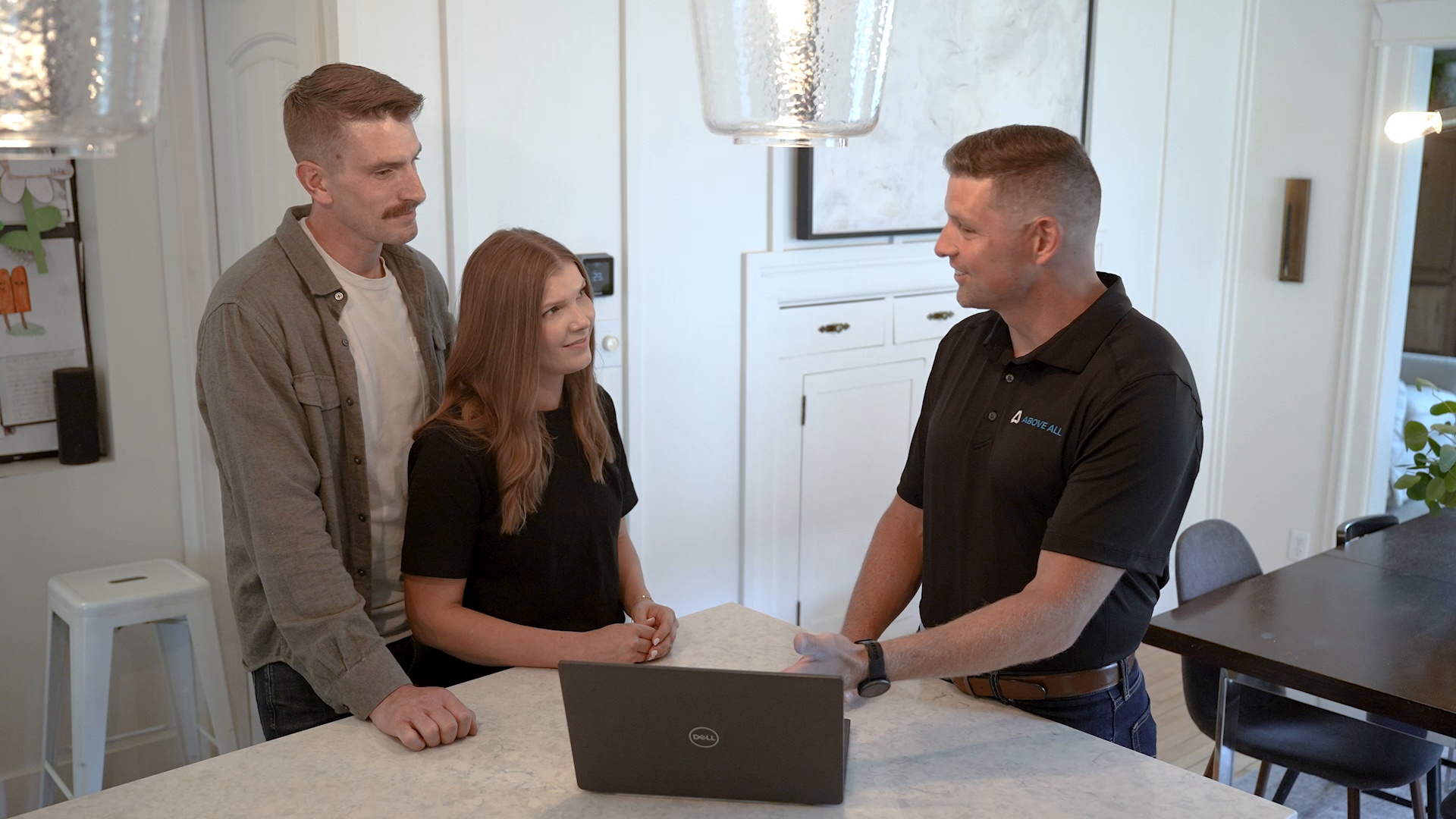 Above All representative discussing a home exterior project with homeowners in their kitchen